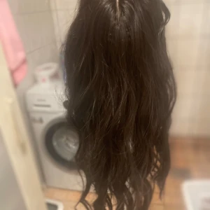 Svart löshår hår del  - Säljer ett svart löshår med clips för enkel applicering. Håret är långt och vågigt, perfekt för att ge extra volym och längd till din frisyr. Clipsen är diskreta och lätta att använda.