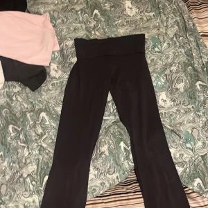 Svarta leggings från Gina Tricot - Snygga svarta leggings från Gina Tricot med hög midja. Perfekta för en bekväm och stilren look. Tillverkade i ett stretchigt material som ger en skön passform.   Yogapants vikbara 