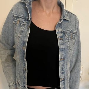 Ljusblå jeansjacka från H&M - Säljer en klassisk ljusblå jeansjacka från H&M. Jackan har en normal passform med långa ärmar och knappar framtill. upptäckte några läcker och ett litet hål på armbågen när jag tvättade upp jackan men den är ändå fantastiskt häftig