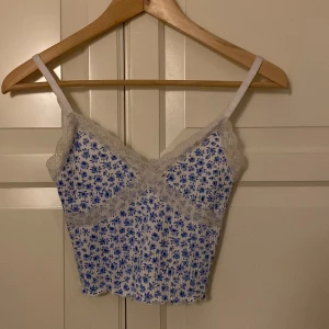 Söt topp med spets - Söt gullig och blommig topp i storlek xxs då den inte passar mig längre, inga tecken på slitage eller liknande och ser ut som ny och toppen är köpt från HM för några år sen, skriv om du är intresserad av o köpa🫶🏼🫶🏼