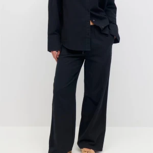 Linnebyxor från Gina Tricot - Snygga svarta byxor från Gina Tricot i en loose passform. Byxorna har en elastisk midja för extra komfort och är tillverkade i ett mjukt material. Perfekta för en avslappnad stil. Använda men i fint skick 