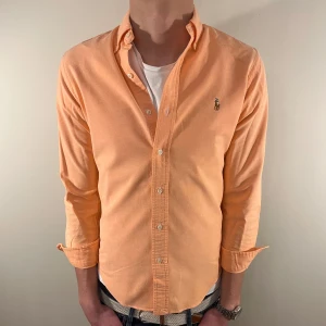 Orange Ralph Lauren skjorta - Perfekt inför sommar/vår!☀️Nu säljer vi ännu en fet polo skjorta som passar till alla tillställningar och skjortan är i mycket bra skick! Du ska kunna uttrycka stil utan att det kostar för mycket!🕺🍾💼🤩  Storlek👔: S Nypris💰: ca 1499kr 