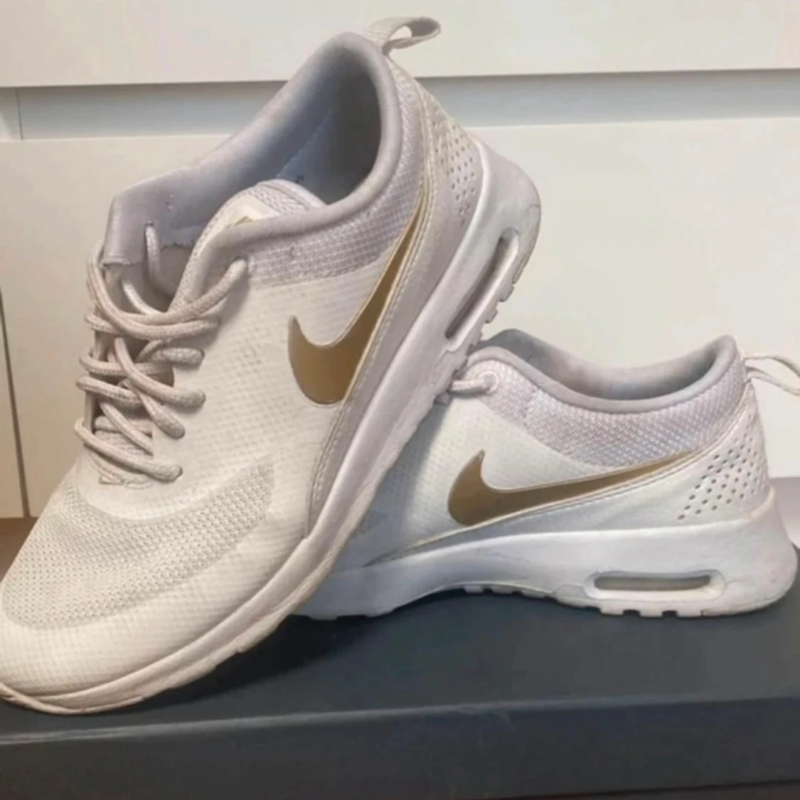Vita Nike sneakers med gulddetaljer