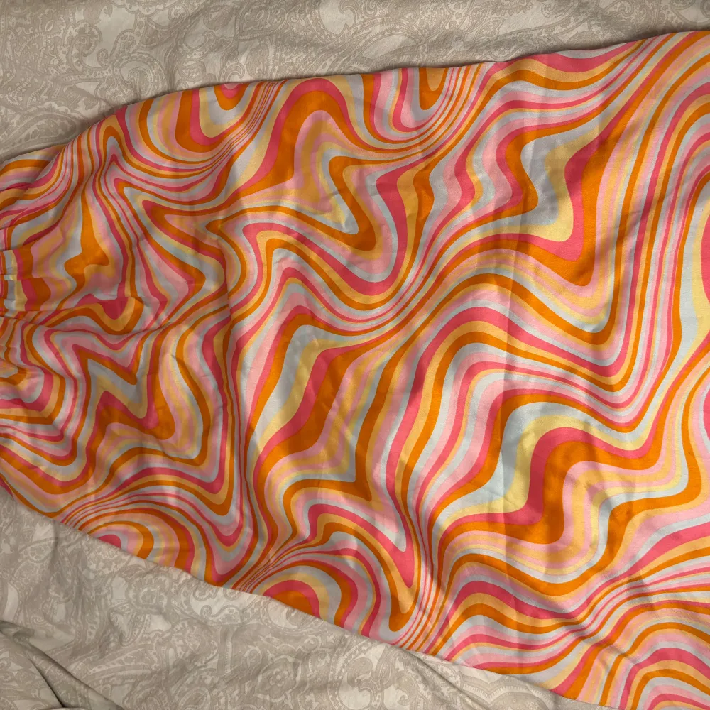 Bilderna blev lite dåligt så skriv om mer bilder om ni är intresserade🥰Säljer en färgglad kjol från Lindex med ett psykedeliskt mönster i rosa, orange, gul och vit. Kjolen har en elastisk midja för bekväm passform och är perfekt för att liva upp garderoben. 🌈. Hameet.