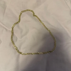Guldfärgat halsband - Snyggt guldfärgat halsband med klassisk kedjedesign. Perfekt för att ge en elegant touch till din outfit. Passar både till vardag och festliga tillfällen.