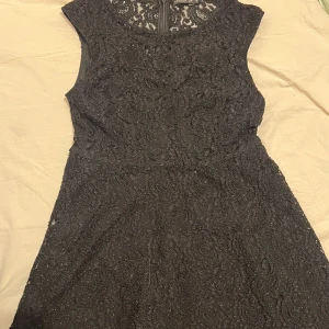 Svart spetsklänning från Stockh LM - Elegant svart klänning i spets från Stockh LM. Klänningen har en vacker struktur med spetsdetaljer och en dragkedja i ryggen. Perfekt för en stilfull look. 