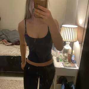 Svart och vit linnetopp - Säljer två-pack linnetoppar i svart och vit färg. De har smala axelband och en tight passform, perfekta för en trendig look. Passar bra till både jeans och kjol.