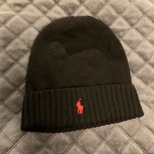 Svart mössa från Ralph Lauren - Snygg svart mössa från Ralph Lauren. En one size i storlek 43cm. 