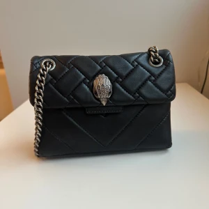 Svart quiltad axelväska från Kurt Geiger - Snygg svart quiltad axelväska från Kurt Geiger med kedjerem. Inga större defekter. Priset kan diskuteras vid snabbt köp. 
