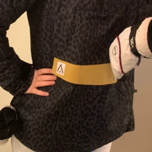 Svart leopardmönstrad jacka - Snygg svart leopardmönstrad jacka med lång ärm och en cool gul detalj på framsidan. Perfekt för att sticka ut i mängden med stil.