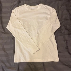 Vit långärmad tröja från fribo - Säljer en klassisk vit långärmad tröja. Perfekt för lager-på-lager eller som den är. Enkel och stilren design.