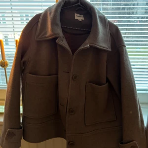 Beige jacka från Kappahl - Snygg beige jacka från Kappahl med klassisk krage och knappar framtill. Jackan har stora fickor och en stilren design som passar perfekt för höst och vår.