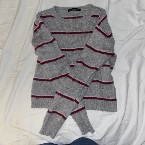 Grå och vinröd/rosa randig tröja från Brandy Melville - Säljer en snygg grå tröja med vinröda och rosa ränder från Brandy Melville. Den är mjuk och varm. Perfekt för vintern!