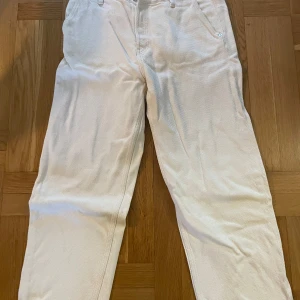 Vita byxor från Weekday - Säljer ett par vita byxor från Weekday. De har en klassisk design med raka ben och fem fickor. Perfekta för en stilren look.