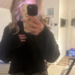 Svart croppad tröja - Säljer en svart croppad tröja med långa ärmar. Perfekt för en avslappnad stil och kan enkelt matchas med olika outfits. Tröjan har en lös passform och är superbekväm att bära. Tröjans material skulle jag även beskriva dom lite fluffigt❤️. 