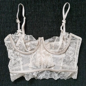 Skir spetsbustier - Elegant beige bustier med vacker spetsdesign och rosetter. Den har anpassningsbara axelband och hakknäppning bak för en perfekt passform. Endast provad. Pris är diskuterbart! :)