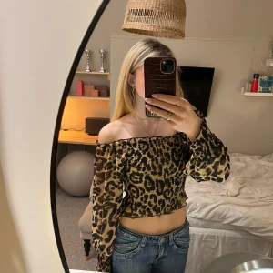 Leopardmönstrad offshoulder topp från SisterS Point - Leopardmönstrad offshoulder topp från SisterS Point. Toppen är croppad och har långa ärmar med en smockad design som ger en snygg passform. Väldigt tredig! 💕