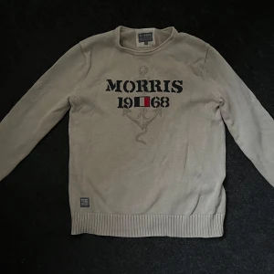 Morris tröja - Säljer en beige tröja från Morris med trycket 'Morris 1968' och ett ankare på framsidan. Tröjan har långa ärmar och ribbade muddar vid ärmslut och nederkant. Perfekt för en avslappnad stil. Skriv om du har frågor!