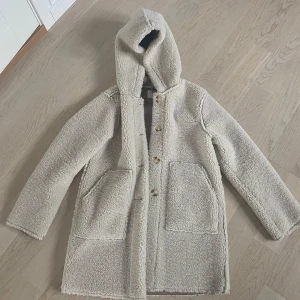 Beige teddyjacka från Zara - Mysig beige teddyjacka från Zara med huva och knappar framtill. Jackan har stora fickor och är perfekt för kyligare dagar. Den är i nyskick💕jackan är i storlek 164 men passar perfekt mig som brukar ha s/m💕pris kan diskuteras 