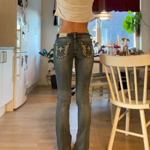 Blå jeans med broderade detaljer - Supersnygga jeans, köppta för 1100kr och jag har använt dom en gång, priset kan diskuteras vid snabb affär. Innerbenslängd:35cm midjemått:83cm. Dom är använda en gång. 