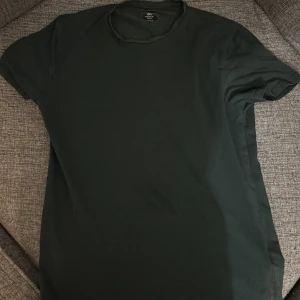 Mörkgrön t-shirt från 157 - Säljer en stilren mörkgrön t-shirt från 157 i storlek medium. Perfekt för en enkel och avslappnad look. T-shirten har en klassisk passform och är kortärmad.