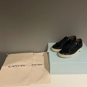 Lanvin - Säljer ett par lanvins i mörkblå i otroligt skick! Färgen ser ut som svart men är blå.  Strl uk 6 vilket motsvarar 40-41  Box och dustbags följer med i köpet. Har ni frågor är det bara att skriva till mig