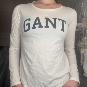  tröja från GANT -  vit långärmad tröja från GANT med mörkblå text på bröstet.