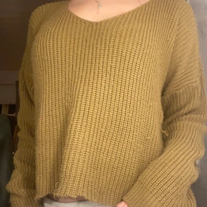 stickad tröja - Brun stickad tröja med v-ringning och långa ärmar. Färgen ser lite konstig ut på bilden 