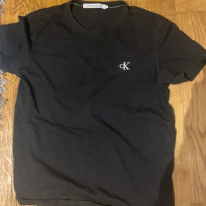 Svart t-shirt från Calvin Klein Jeans - Snygg svart t-shirt från Calvin Klein Jeans med det ikoniska CK-logotypen broderad på bröstet. Perfekt för en stilren och avslappnad look.