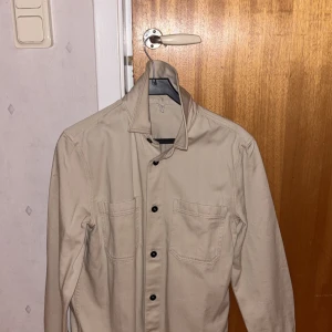 Overshirt NK M - Beige Overshirt från NK i storlek M. Aldrig använd. Fick i present i somras, passar inte mig och glömde göra retur. 