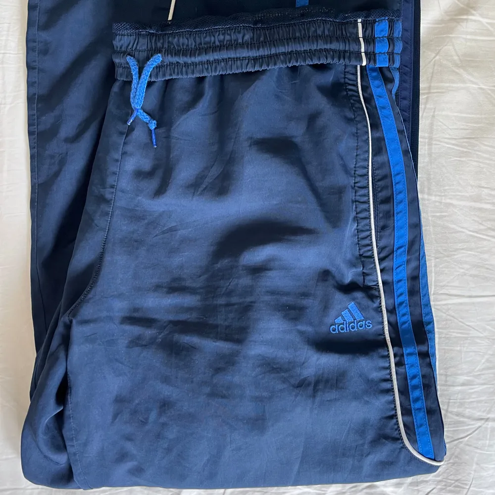 Mörkblåa adidas trackpants, fickor finns, perfekta till att dansa i och har resårband så kan sitta både low waist men även högre ifall man vill. De är stretchiga vid midjan så kan skjusteras i storlek. . Jeans & Byxor.