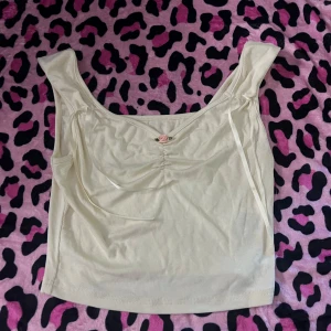 Söt topp  - Topp med snörning och en liten blomma som dekorationer 