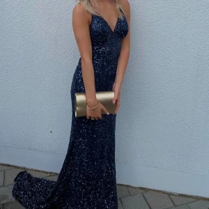 Balklänning - Säljer min ÄLSKADE balklänning. Den är från dressroom och kostar nypris 4990kr. Den är använd två baler och har lossnat några paljetter på ett ställe (finns bild) men syns inte när klänningen är på eftersom det är släpet de har lossnat på och släpet har så mycket extra tyg. Kan tänka mig att gå ner i pris om det önskas! 