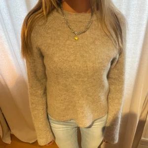 Beige stickad tröja - Mysig beige stickad tröja som är perfekt för kyligare dagar. Den har en enkel och stilren design med långa ärmar och en normal passform. Perfekt att matcha med jeans för en avslappnad look.