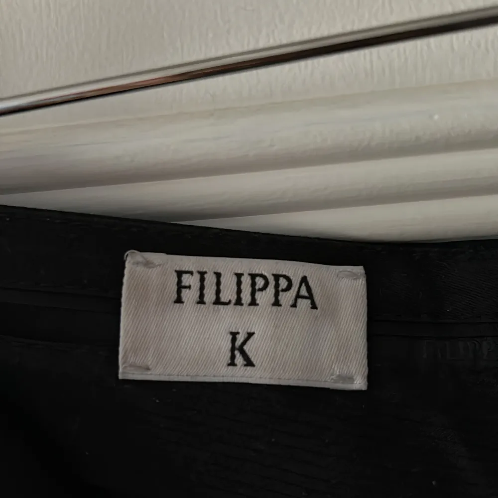 Säljer ett par eleganta svarta kostymbyxor från Filippa K. De är högmidjade och har en klassisk straight passform som passar perfekt för både formella och semi-formella tillfällen. Materialet känns lyxigt och hållbart, vilket gör dem till ett tidlöst tillskott i garderoben.. Jeans & Byxor.