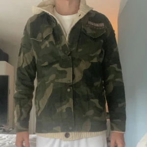 Camouflagejacka från Abercrombie & Fitch - Säljer en snygg camouflagejacka från Abercrombie & Fitch i storlek M unisex. Jackan har en militärstil med flera fickor och knappar framtill. Perfekt för höst och vår som en overshirt. Pris kan diskuteras vid snabb affär. 