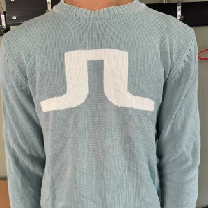 J.Lindeberg Tröja Ljusblå - J.Lindeberg i ljusblå färg med stor logga på magen. Märkbar användhet. Passar bra till lite vad som helst. 