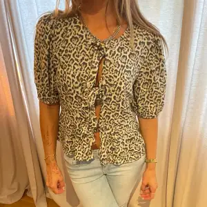 Säljer en supercool leopardmönstrad topp med knyt framtill. Den har trekvartsärmar och en tight passform som verkligen framhäver figuren. knyt blus