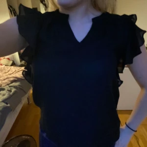 Svart blus  - Söt vanlig svart blus med volang vid armarna! 