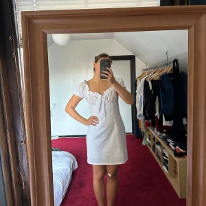 Vit klänning - Söt vit klänning med puffärmar och rosett. Perfekt till studenten eller som sommarklänning! Använd en gång!