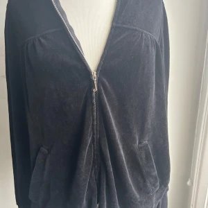 Svarta mjukisbyxor från Juicy Couture - Säljer en hoodie o ett par svarta mjukisbyxor från Juicy Couture. De är supermjuka och bekväma, perfekta för en chill dag hemma eller en avslappnad utflykt. Byxorna har en snörning i midjan för bästa passform. Materialet känns lyxigt och är i sammet.