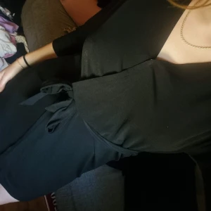 Svart omlottklänning - Säljer en elegant svart omlottklänning med trekvartsärm. Klänningen har en knytning i midjan som ger en smickrande passform. Perfekt för både vardag och fest!