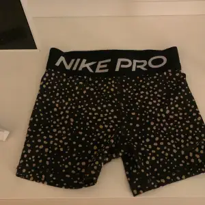 Säljer ett par svarta Nike Pro shorts med guldiga prickar. De är perfekta för träning och har en tight passform. Shortsen är i mycket bra skick och har en elastisk midja för extra komfort. Perfekta för gymmet eller löprundan!❤️