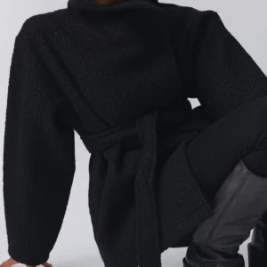 Svart teddyjacka med bälte - Säljer en supermysig svart teddyjacka som är perfekt för höst och vinter. Den har långa ärmar och ett bälte i midjan för en snygg passform. Jackan är i mycket bra skick och passar perfekt för både vardag och fest. Perfekt för att hålla sig varm och stilren!