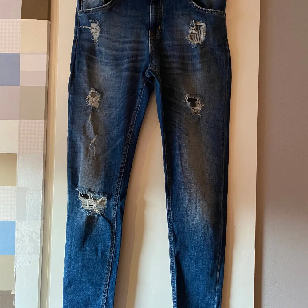 Säljer ett par blå jeans från 157 i storlek M. De har en slouchy passform och är snyggt slitna med flera hål för en trendig look. Perfekta för en avslappnad stil! 🕶️. Jeans & Byxor.