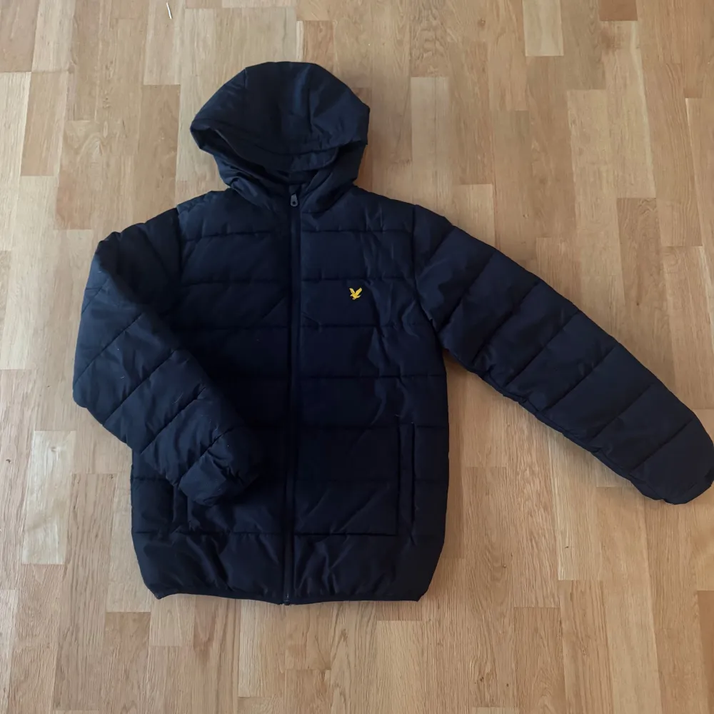 Säljer en svart pufferjacka från Lyle & Scott i storlek 12-13 år. Jackan har en luva och dragkedja framtill. Perfekt för vintern! Den är i mycket bra skick och använt ett fåtal gånger.. Jackor.