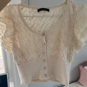 Vit spetsblus från Dilvin - Säljer en superfin vit spetsblus från Dilvin. Den har korta ärmar med volangdetaljer och knappar framtill. Perfekt för sommarens alla tillfällen! 💕 Jag har knappt använt denna fina blus, eftersom den inte passade 