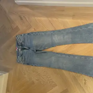 Säljer ett par klassiska blå jeans i bra skick. De har en snygg, lite tvättad look och är perfekta för vardagsbruk. Passformen är normal och de har en traditionell dragkedja och knapp framtill. Perfekta för både höst och vår!