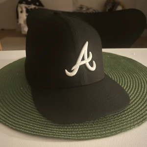 New era Atlantas braves keps - New era Atlantas braves keps i nytt skick knappt använd, storlek 58,7cm. Den var helt rak då jag köpte den men har böjt den lite, riktigt laidback keps.