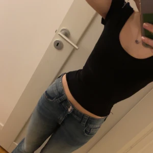 Svart shape topp - Säljer en svart croppad topp i mycket bra skick. Den har en tight passform och korta ärmar, perfekt för sommaren. Toppen är stilren och enkel att matcha med olika outfits.